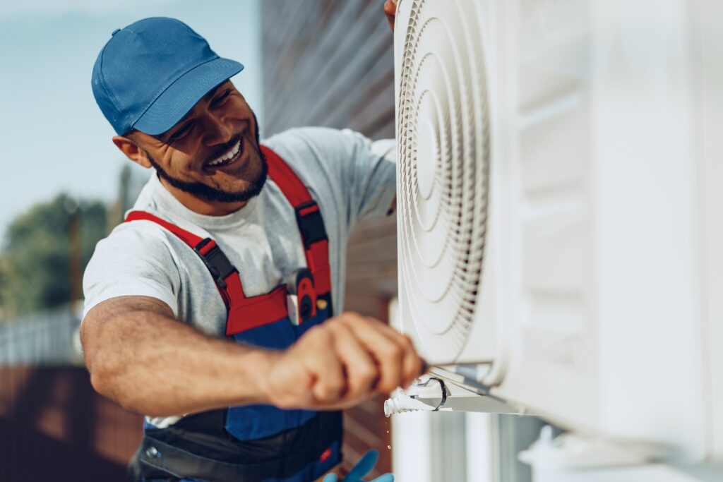 Young man repairman checking an outside air conditioner unit