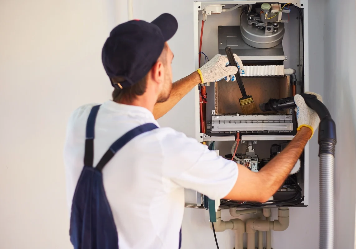 tech cleaning and maintaining hvac system