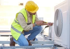 worker in safety gear working on hvac system